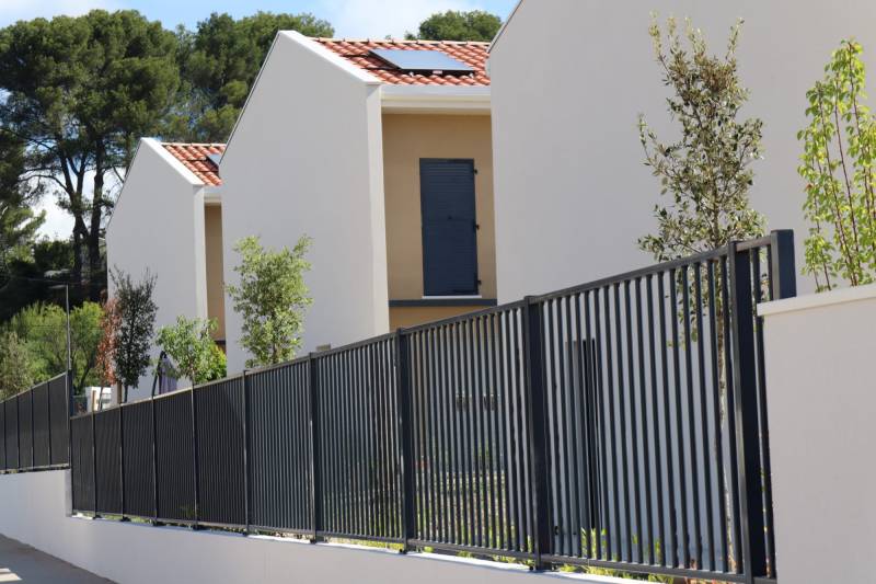 Pose d'une clôture à barreaux sur un muret autour d'un lotissement à Ventabren en 2024